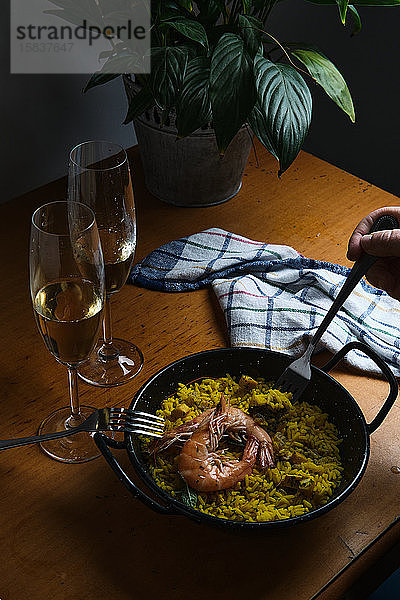 ein Teller mit spanischer Paella für zwei Personen  begleitet von zwei Gläsern
