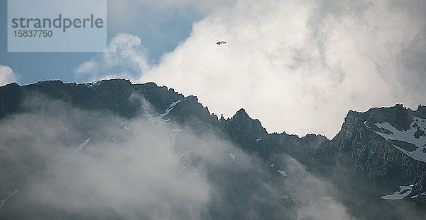 Ein Hubschrauber fliegt hoch über dem Mount Currie an einem Sommertag in Pemberton  Britisch-Kolumbien.