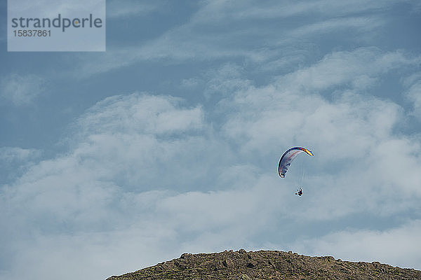Fallschirmspringer fliegt bei blauem Himmel an einem sonnigen Tag