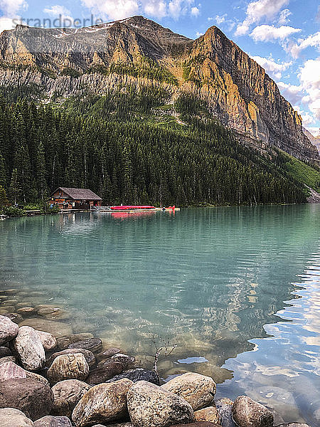 Ufer des Lake Louise mit Bootshaus und Bergen in der Ferne.