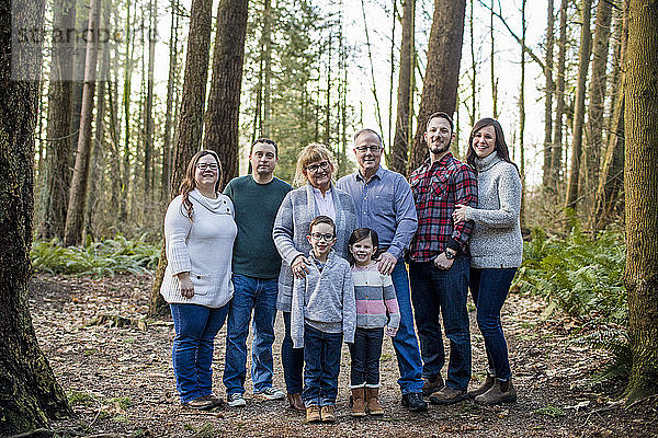 Porträt einer glücklichen achtköpfigen Familie im Wald.
