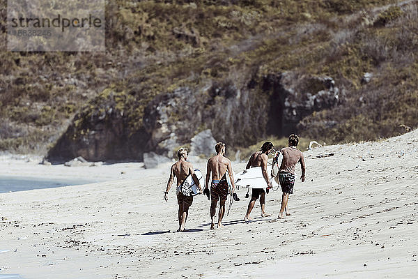 Nicht erkennbare Surfer gehen auf die Klippe zu