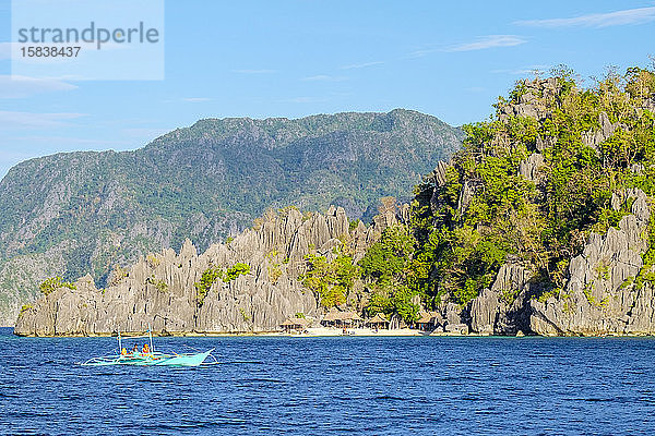 Auslegerboot passiert Dorf auf Coron Island  Philippinen