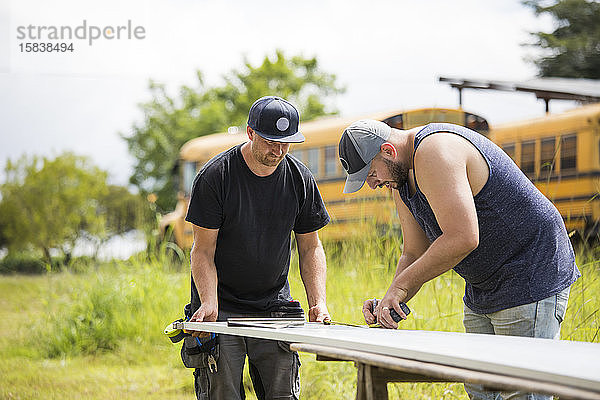 Zwei Männer arbeiten an der Montage von Sonnenkollektoren.