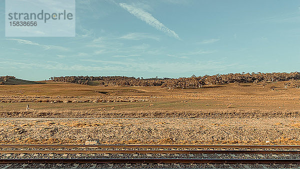 Eisenbahn- und Bauernlandschaft mit blauem Himmel