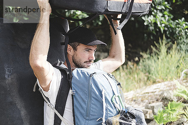 Porträt eines Bergsteigers mit Crashpad und Rucksäcken