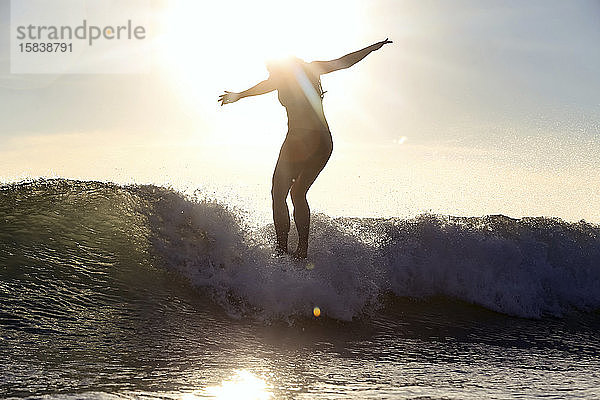 Silhouette eines Surfers bei Sonnenuntergang