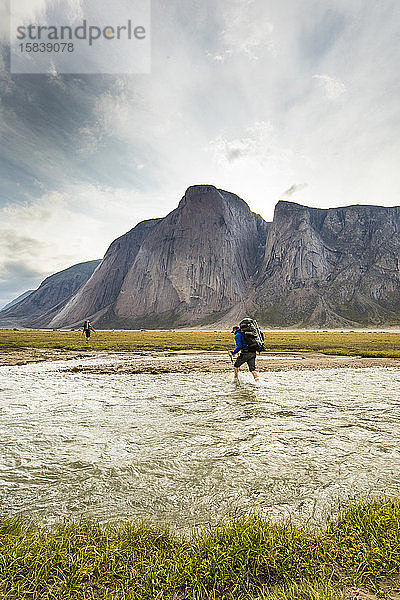 Bergsteiger überqueren Flüsse und arktische Tundra  um illusorische Berge zu erreichen.