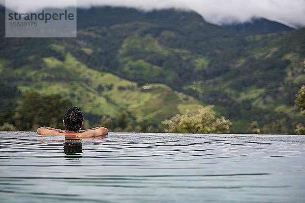 Mann entspannt sich im Schwimmbad im zentralen Hochland von Sri Lanka