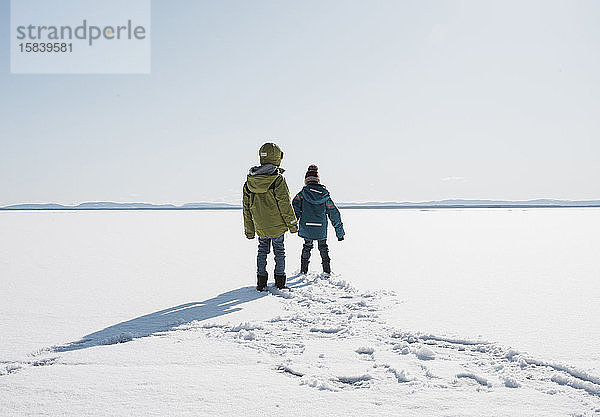 Kinder  die in Schweden über einen zugefrorenen See laufen