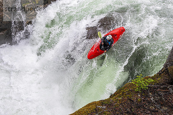 Ein Wildwasser-Kajakfahrer paddelt über einen Wasserfall auf dem Cheakamus-Fluss