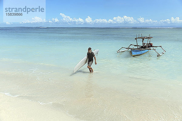 Titel Surfer mit Surfbrett am Strand