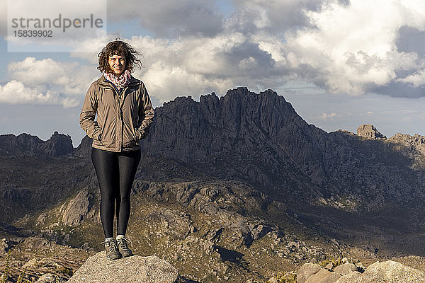 Frau auf schöner Landschaft mit Höhenfeldern und felsigen Bergen