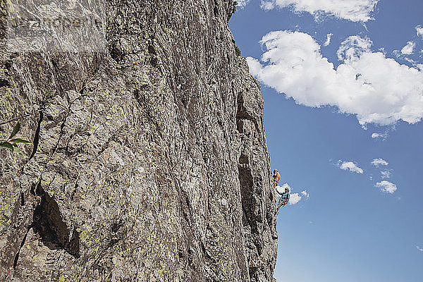 Zwei Menschen klammern sich beim Felsklettern am Rand einer Klippe fest  Wyoming