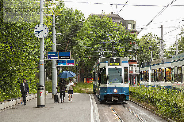 Menschen nehmen das einfahrende Tram an der Station Milchbuck  ZÃ¼rich  Schweiz