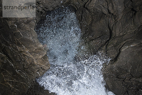 Pazifische Wellen stürzen durch eine Meereshöhle im Leo Carillo State Park