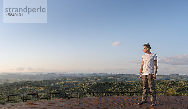 Erwachsener Mann schaut auf das Panorama der Berge  im Sommer