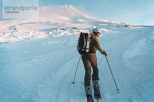 Mann häutet sich bei Sonnenaufgang im Winter zum Mt. Hood hinauf