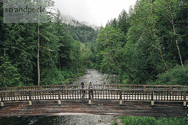 Ein junges Paar genießt eine Wanderung auf einer Brücke im pazifischen Nordwesten.