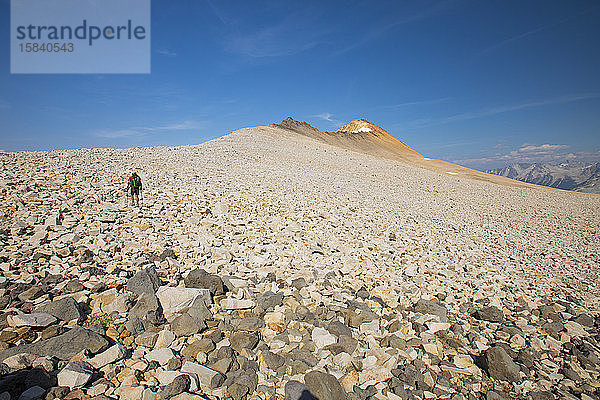 Backpacker durchquert Geröllfeld auf dem Weg zum Orchre Mountain.