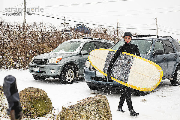 Frau macht sich an einem verschneiten Tag zum Surfen bereit