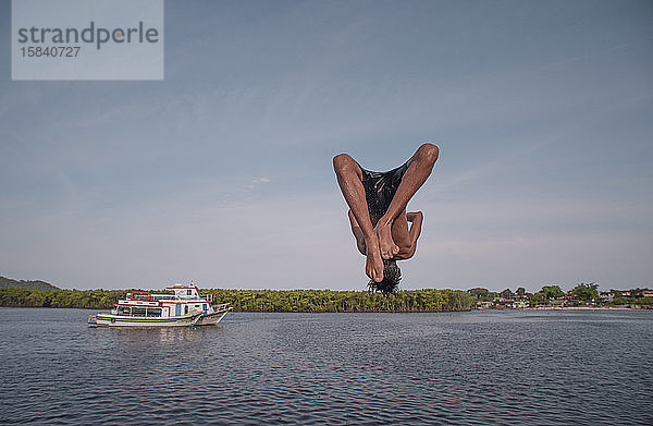 Junge kopfüber nach einem Sprung vom Pier