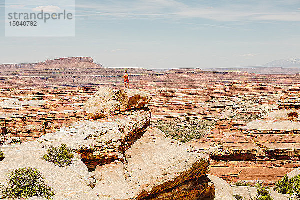 eine Wandererin nimmt den Blick auf einen Felsvorsprung mit Blick auf das Labyrinth Utah