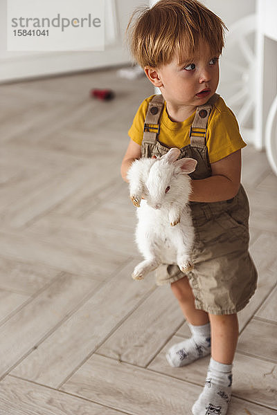 Junge spielt zu Ostern mit einem Kaninchen