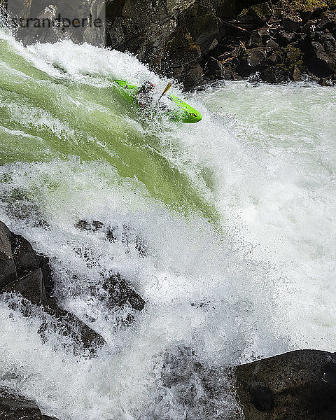 Ein Wildwasser-Kajakfahrer paddelt über einen Wasserfall am Callaghan Creek.