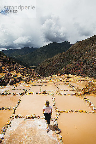 Junge Frau steht in der Nähe der berühmten Salzminen in Peru