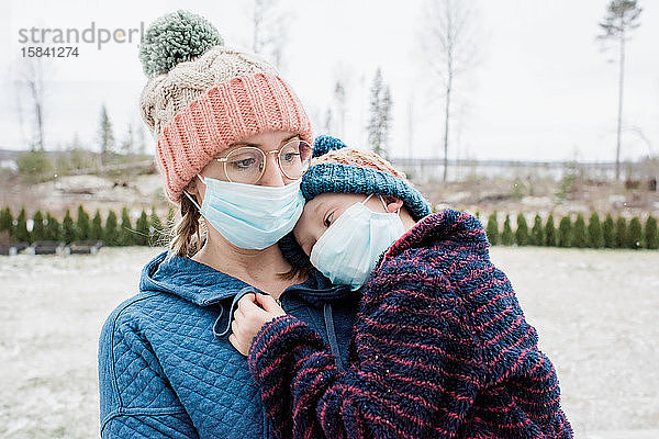 Mutter  die einen Sohn mit Gesichtsmaske trägt  als Schutz vor Virus und Grippe