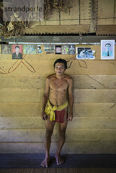 Porträt eines Mannes des Mentawai-Stammes mit Fotos seiner Kinder