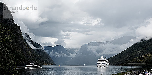 Kreuzfahrtschiff fährt durch den Nebel in einem atemberaubenden Fjord in Norwegen