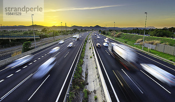 Geschäftige Autobahn bei Sonnenuntergang  Fahrzeuge kommen und gehen  Stress in der Stadt -
