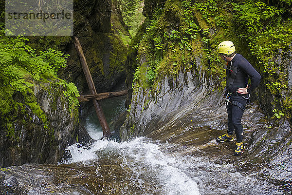 Hoher Winkel eines Mannes  der über den Rand eines Wasserfalls schaut