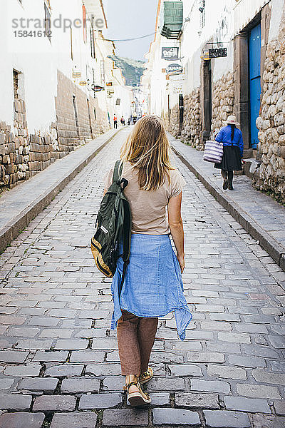 Eine junge Frau geht die Straße in der Stadt Cusco  Peru  entlang