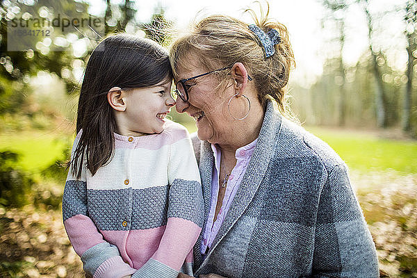 Süßes Mädchen lächelt Oma im Freien an.