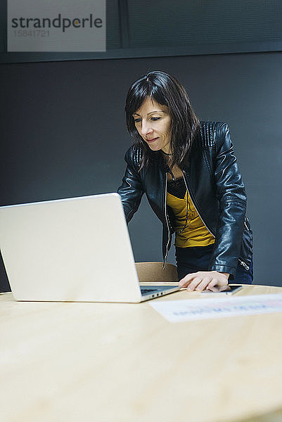 Weibliche Geschäftsfrau betrachtet Laptop im Büro