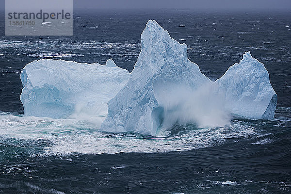 Eisberg mit brechender Welle in Neufundland