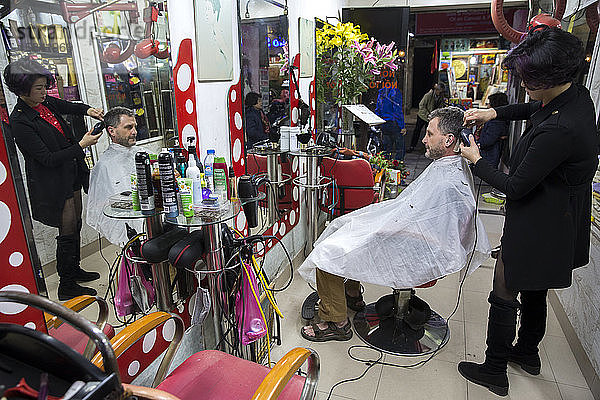 Ein Mann lässt sich in einem vietnamesischen Friseurladen in Hanoi  Vietnam  die Haare schneiden.
