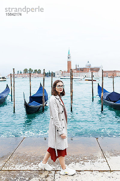 junger Tourist in Kleid und Mantel auf Kanal- und Veneziagondel