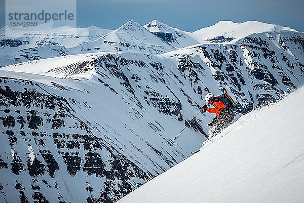 Ein Mann fährt tagsüber auf einem Berg in Island Ski