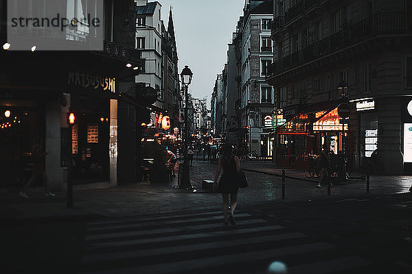 Nächtliche Straße in Paris mit Stadtlichtern und Stadtleben