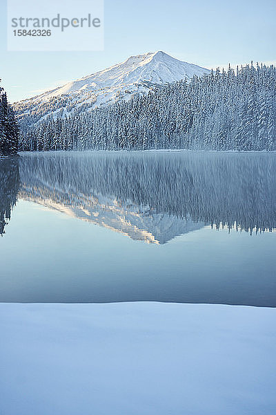 Landschaftlich reizvoller Berg im Winter  der sich im See spiegelt