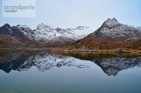 Schneebedeckte Berge spiegeln sich perfekt im Bergsee