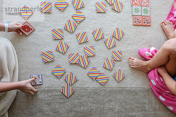 Draufsicht auf Kinder  die Kartenspiel spielen und auf einem Teppich sitzen
