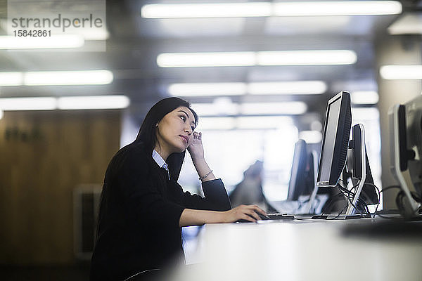 junge asiatische frau mit papier in einem büro bei der arbeit