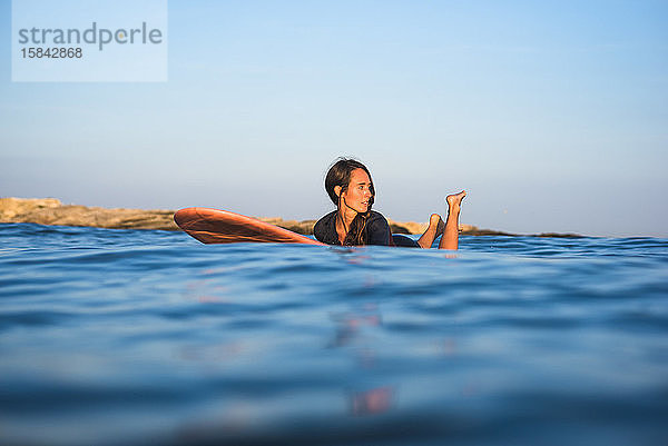 Wasserfreundinnen surfen gemeinsam bei Sonnenuntergang
