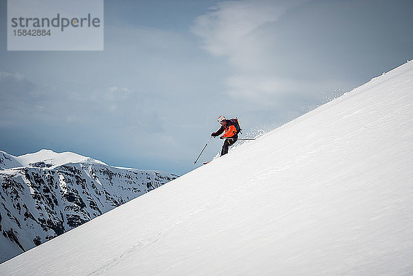 Skifahrender Mann in Island mit Bergen im Rücken