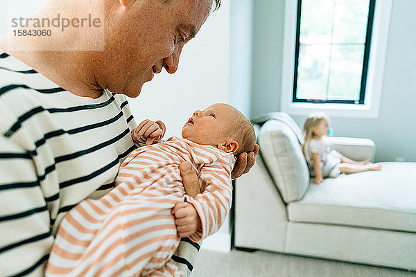 Ausgeschnittenes Nahaufnahme-Portrait eines Vaters  der ein kleines Mädchen hält